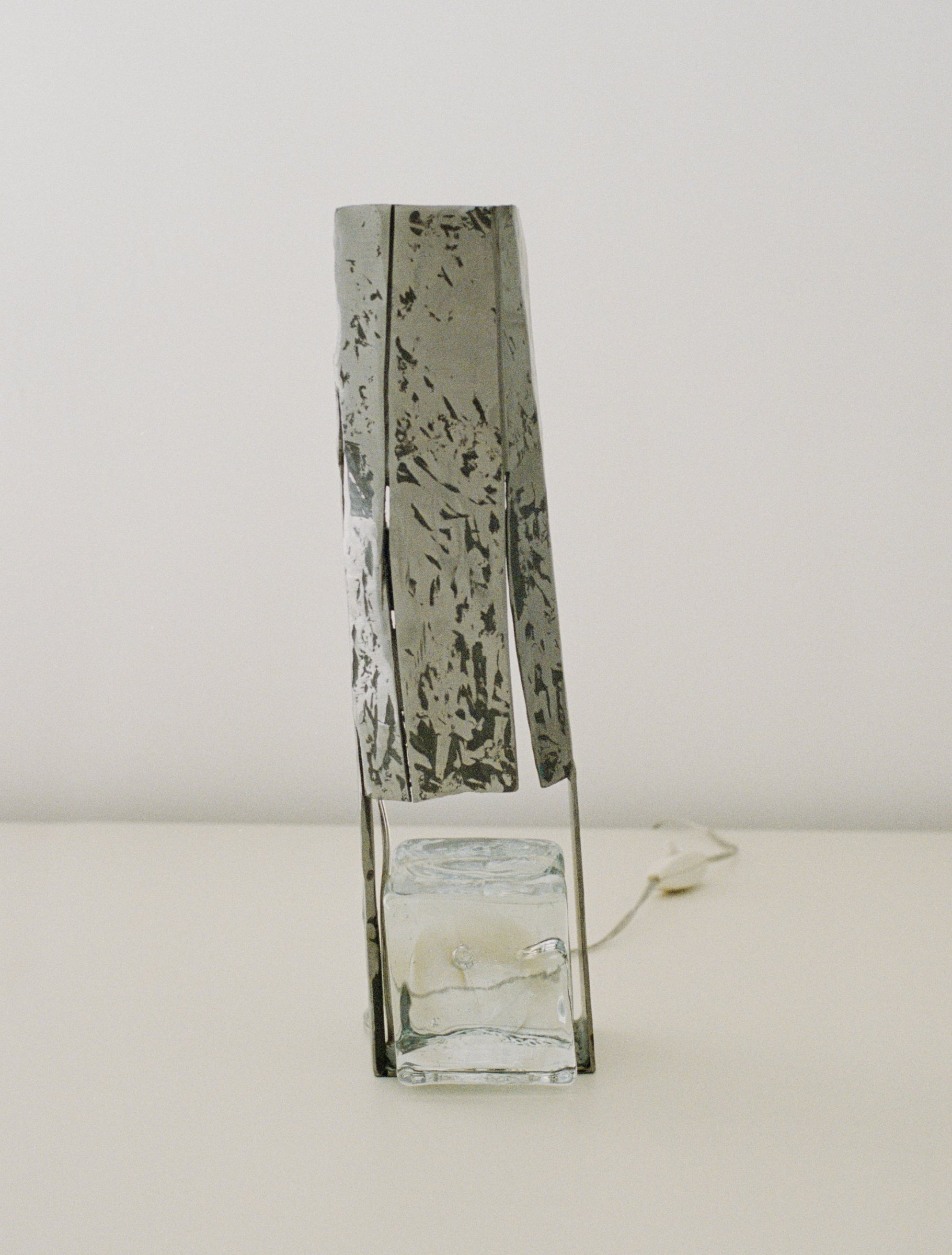 Lamp by Grace Prince, a hammered metal shade on a cast glass base